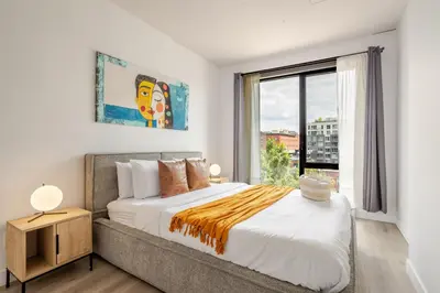 a bedroom with a large bed and a window at Modern Heritage Stay Upscale 2BR in Old Port in Montréal
