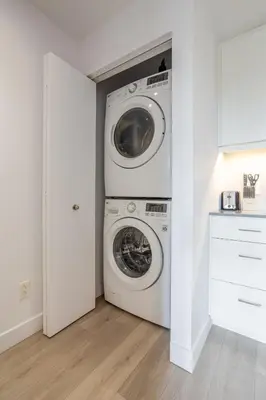 a washer and dryer in a white laundry room at Modern Heritage Stay Upscale 2BR in Old Port in Montréal