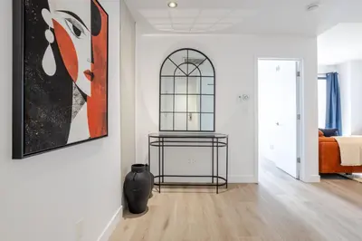 a living room with a painting on the wall and a vase at Modern Heritage Stay Upscale 2BR in Old Port in Montréal