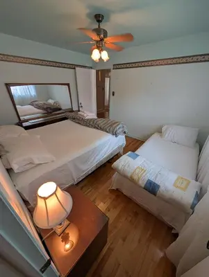a bedroom with two beds and a ceiling fan at 2 beds in a private room B with a free parking -15 min from downtown in Longueuil