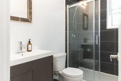 a bathroom with a toilet and a glass shower at Appart lumineux et chaleureux in Montréal