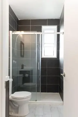 a bathroom with a shower with a toilet and a sink at Appart lumineux et chaleureux in Montréal