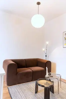 a living room with a brown couch and a table at Appart lumineux et chaleureux in Montréal