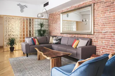 a living room with two couches and a brick wall at MTLVacationRentals - The City Chalet in Montréal