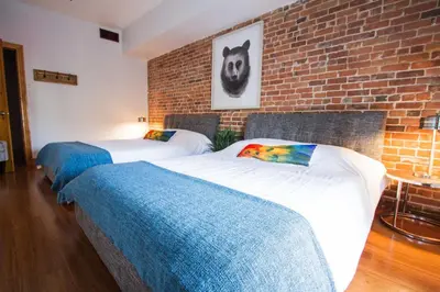 two beds in a room with a brick wall at MTLVacationRentals - The City Chalet in Montréal