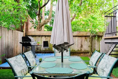 a patio with a table with a umbrella and chairs at Confort Suprême Grand Appartement 3 Chambres Design in Montréal