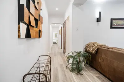 a hallway of a house with a couch and a plant at Confort Suprême Grand Appartement 3 Chambres Design in Montréal