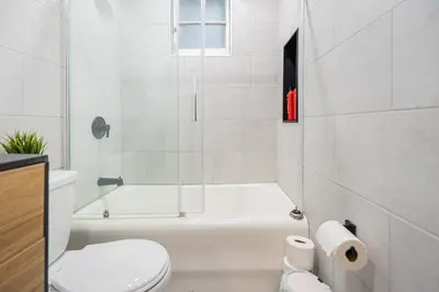 a bathroom with a shower and a toilet and a tub at Confort Suprême Grand Appartement 3 Chambres Design in Montréal