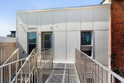 a white facade of a building with a staircase at Habitat in Montréal
