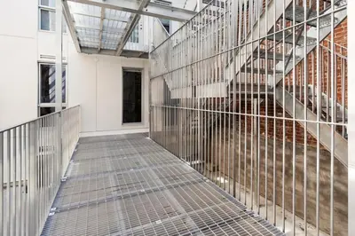 a hallway of a building with a metal fence at Habitat in Montréal