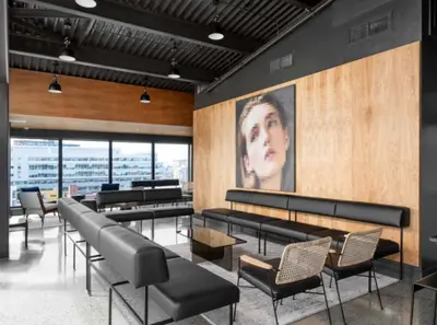 a waiting room with black chairs and tables and a painting at Cozy apartment-Old Port Montreal in Montréal