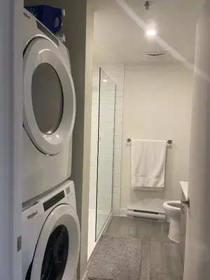 a bathroom with a washing machine and a toilet at Cozy apartment-Old Port Montreal in Montréal