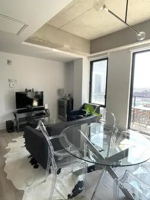 a living room with a glass table and chairs at Loft moderne au coeur de Montreal in Montréal