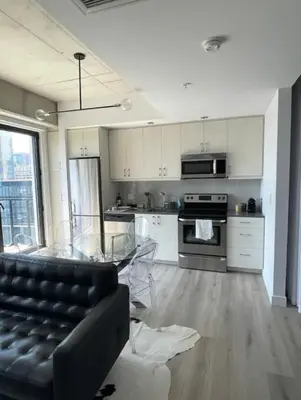a living room with a glass table and a kitchen at Loft moderne au coeur de Montreal in Montréal