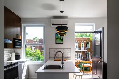 a kitchen with a sink and two windows at Appartement cozy et lumineux avec parking in Montréal
