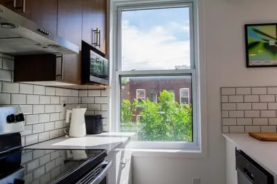a kitchen with a large window in a kitchen at Appartement cozy et lumineux avec parking in Montréal
