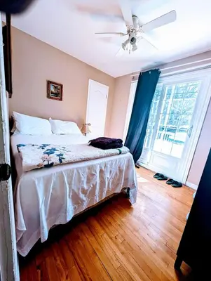 a bedroom with a bed and a ceiling fan at Private roomC Fee parking 15min downtown in Longueuil