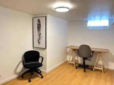 a room with two desks and two chairs at Stylish 6-BR House close to DT with free parking in Brossard