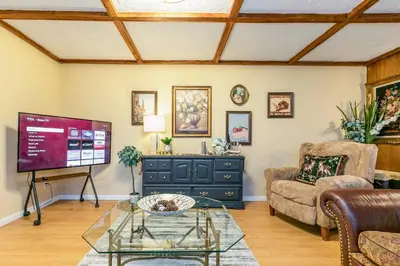 a living room with a tv and a couch and a table at Stylish 6-BR House close to DT with free parking in Brossard