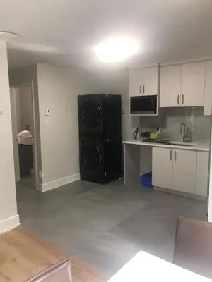 a kitchen with a black refrigerator in a room at Peaceful oasis near airport private entrance in Pointe-Claire