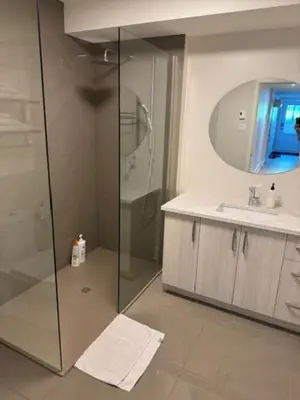 a bathroom with a shower and a sink and a mirror at All inclusive pied à terre near airport 2nd bed extra twenty dollars cash in Pointe-Claire