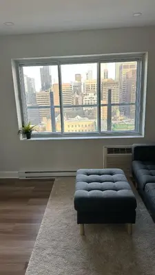 a living room with a couch and a large window at Great view 1BDRM APTR in heart of Montreal DWTN in Montréal