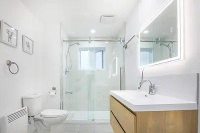 a bathroom with a shower and a sink and a toilet at 2 bedroom, subway, free parking. in Longueuil