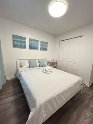 a bedroom with a large white bed in a room at 2 bedroom, subway, free parking. in Longueuil