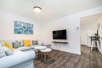 a living room with a couch and a tv at 2 bedroom, subway, free parking. in Longueuil