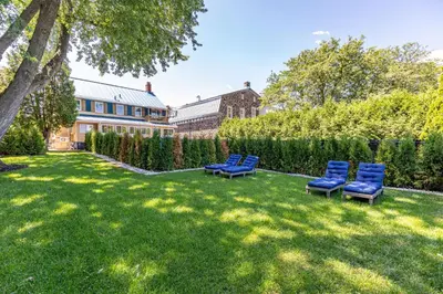 a yard with two blue chairs in front of a house at Escapade Chambly in Chambly