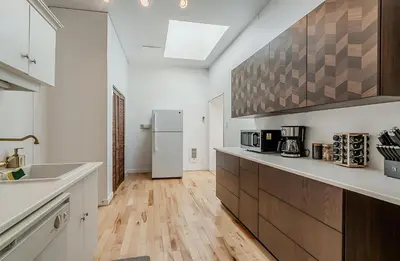 a kitchen with a sink and a refrigerator at La Galerie Privée Luxe & Impeccable Stay in Montréal