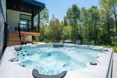 a hot tub in the backyard of a house at Spa & Adventure - Chalet Valikas in Weedon-Centre