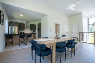a kitchen and dining room with a wooden table and chairs at Spa & Adventure - Chalet Valikas in Weedon-Centre