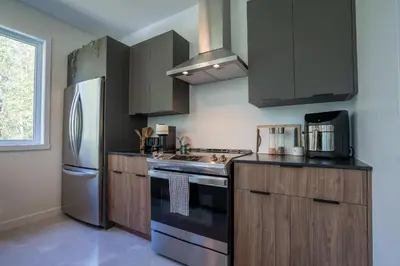 a kitchen with a stove and a refrigerator at Spa & Adventure - Chalet Valikas in Weedon-Centre