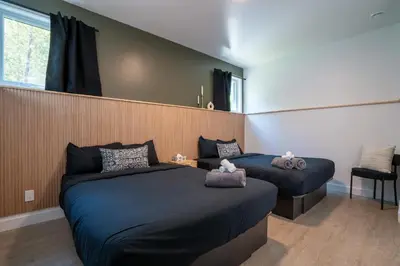 a bedroom with two beds and a window at Spa & Adventure - Chalet Valikas in Weedon-Centre