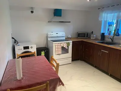 a kitchen with a table and a stove top oven at Résidence le HAvre in Laval