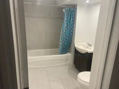 a bathroom with a tub and a toilet and a sink at Résidence le HAvre in Laval