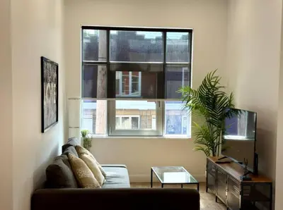 a living room with a couch and a window at The Royale Apartments 1 in Trois-Rivières