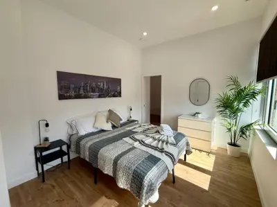 a white bedroom with a bed and a mirror at The Royale Apartments 1 in Trois-Rivières