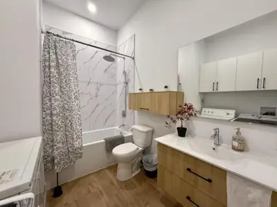 a bathroom with a toilet and a sink and a shower at The Royale Apartments 1 in Trois-Rivières