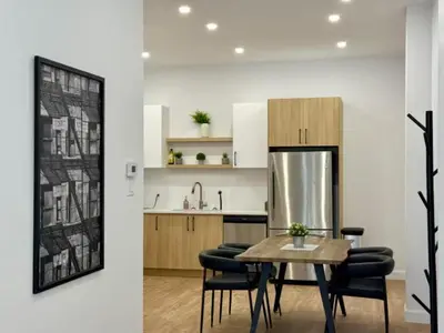 a kitchen with a table and chairs and a refrigerator at The Royale Apartments 1 in Trois-Rivières