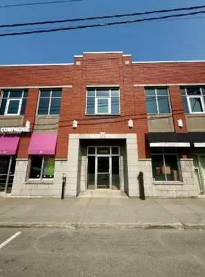 a red brick building with a door on a street at The Royale Apartments 1 in Trois-Rivières