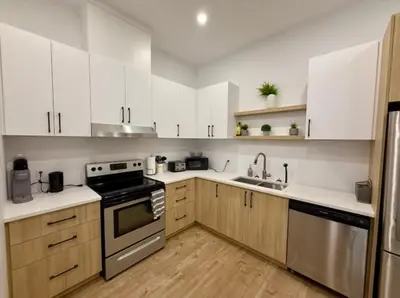 a kitchen with white cabinets and stainless steel appliances at The Royale Apartments 1 in Trois-Rivières