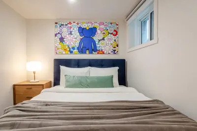 a bedroom with a bed with a painting on the wall at Plateau Powerhouse 5BR and 2BA Apt in Montréal