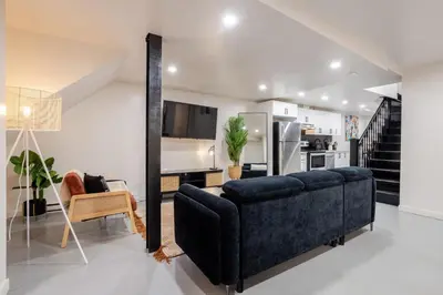 a living room with a blue couch and a kitchen at Plateau Powerhouse 5BR and 2BA Apt in Montréal