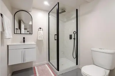 a bathroom with a shower and a toilet and a sink at Plateau Powerhouse 5BR and 2BA Apt in Montréal