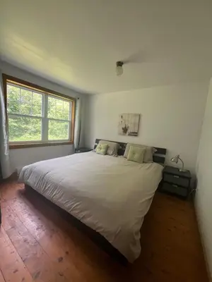 a bedroom with a large white bed with a window at Simple de nature in Austin