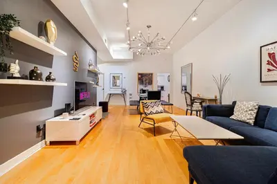 a living room with a blue couch and a table at Suite La Madame - Designer Downtown Nest in Montréal