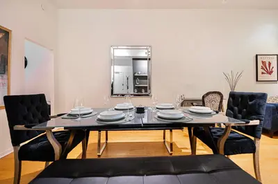 a dining room with a table with chairs and a mirror at Suite La Madame - Designer Downtown Nest in Montréal