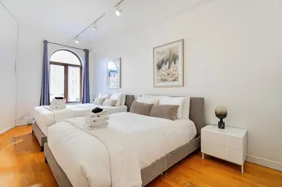 a bedroom with two beds and a couch at Suite La Madame - Designer Downtown Nest in Montréal